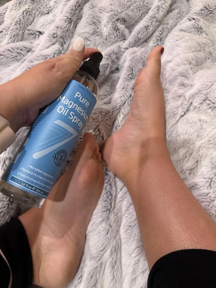 Customer spraying Seven Minerals Magnesium Oil on her feet